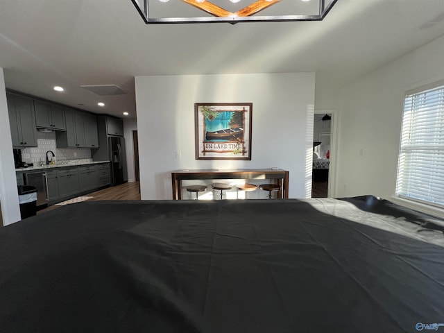 interior space featuring hardwood / wood-style flooring, black fridge, and sink