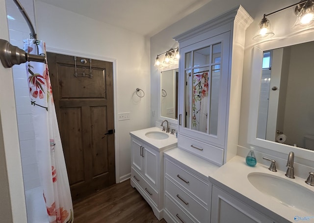 full bathroom with hardwood / wood-style flooring, vanity, shower / tub combo with curtain, and toilet