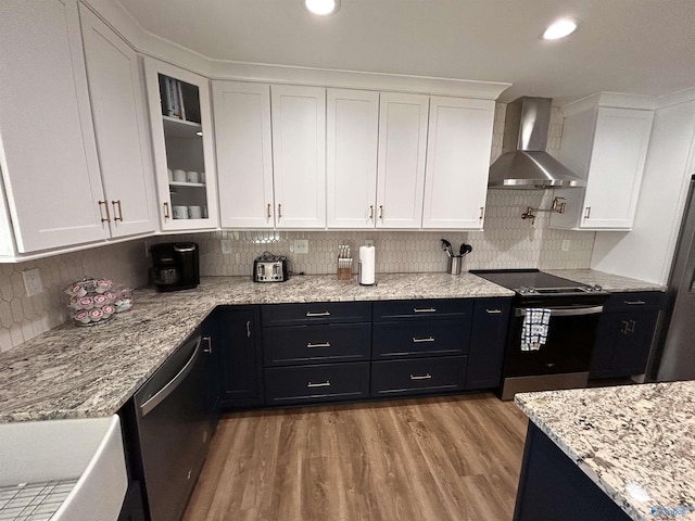 kitchen with white cabinets, stainless steel appliances, and wall chimney exhaust hood