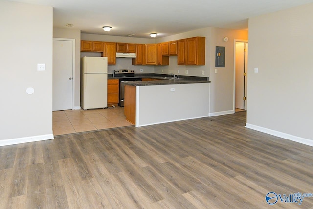 4114 Triana Blvd, Huntsville, AL 35802 - kitchen with freestanding refrigerator, stainless steel range with electric cooktop, electric panel, under cabinet range hood, and dark countertops