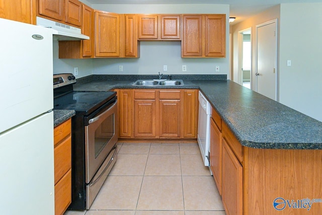 4114 Triana Blvd, Huntsville, AL 35802 - kitchen with white appliances, under cabinet range hood, dark countertops, a peninsula, and brown cabinets
