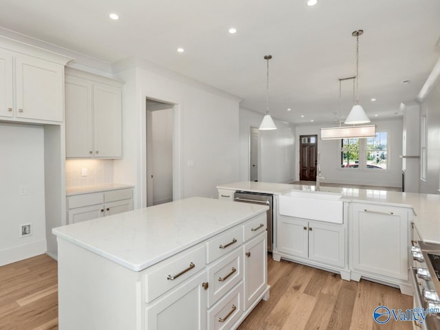 kitchen featuring tasteful backsplash, white cabinetry, a kitchen island, pendant lighting, and stainless steel appliances