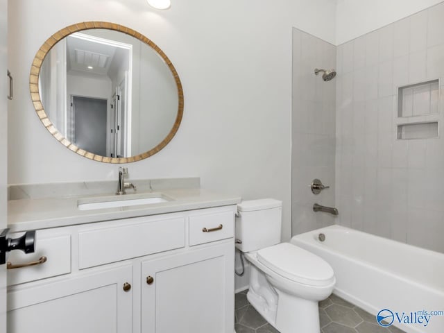 full bathroom featuring tile patterned flooring, vanity, tiled shower / bath, and toilet