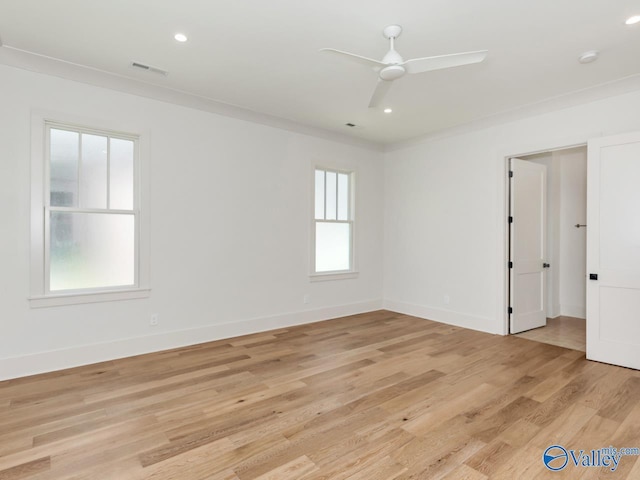 spare room with crown molding, light hardwood / wood-style flooring, and a healthy amount of sunlight