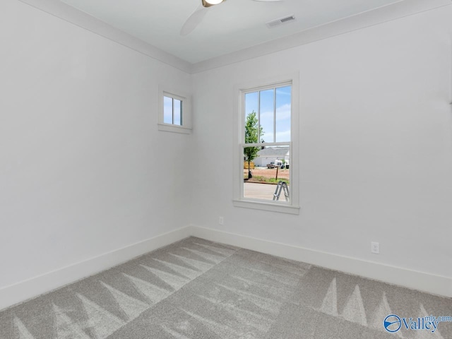 carpeted spare room featuring crown molding and ceiling fan