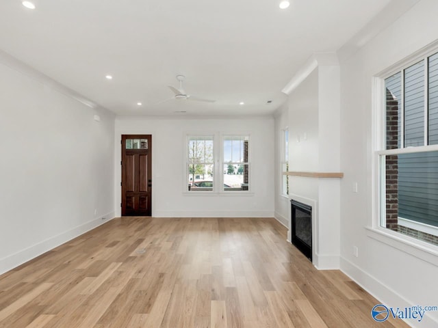 unfurnished living room with crown molding, light hardwood / wood-style floors, and ceiling fan