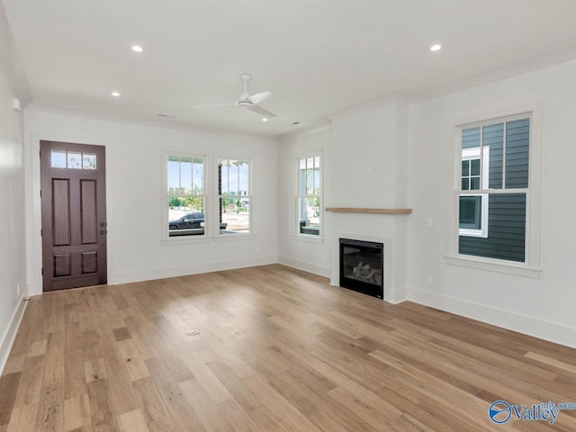 unfurnished living room featuring crown molding, ceiling fan, and light wood-type flooring