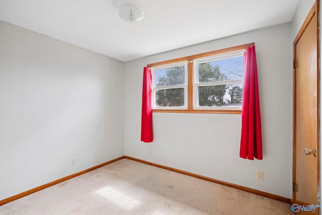 carpeted spare room featuring baseboards