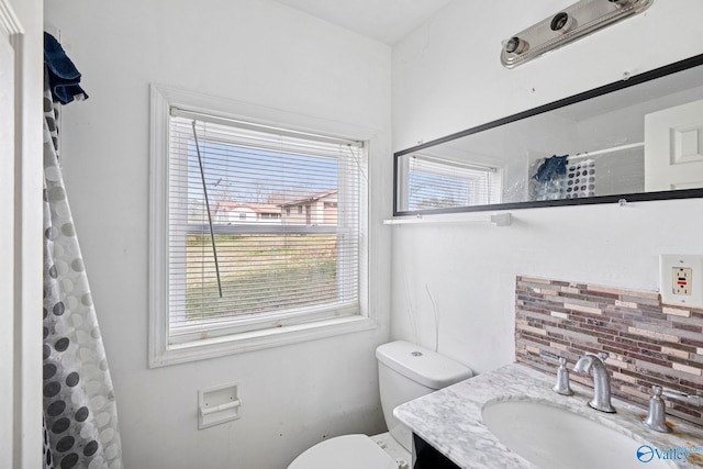 bathroom with vanity, a shower with shower curtain, toilet, and tasteful backsplash