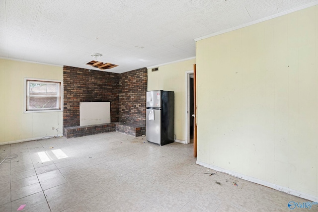 unfurnished living room with visible vents, baseboards, a textured ceiling, and ornamental molding