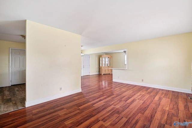 unfurnished room with baseboards and wood finished floors