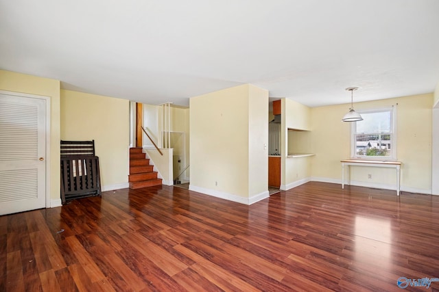 spare room featuring stairway, baseboards, and wood finished floors