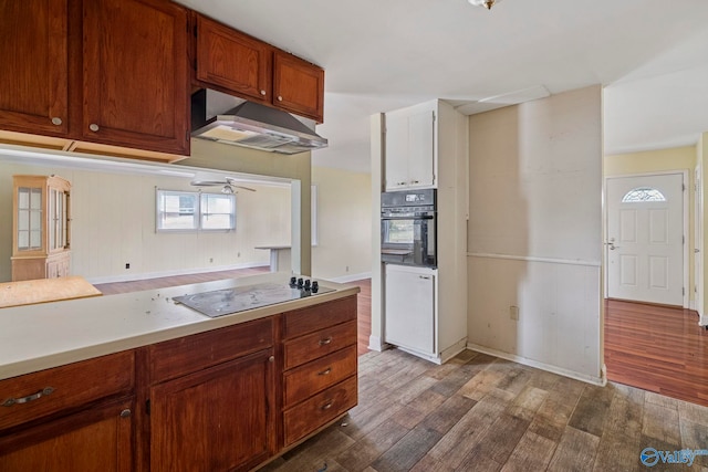 kitchen featuring a ceiling fan, dark wood-style floors, black appliances, light countertops, and under cabinet range hood