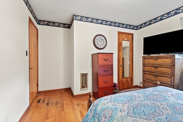 26740 Nick Davis Rd, Athens, AL 35613 - bedroom with a textured ceiling, light wood-style floors, heating unit, and baseboards