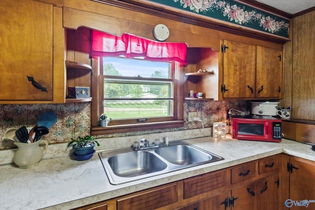 26740 Nick Davis Rd, Athens, AL 35613 - kitchen featuring a sink, open shelves, brown cabinetry, backsplash, and light countertops