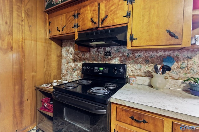 26740 Nick Davis Rd, Athens, AL 35613 - kitchen with black range with electric stovetop, light countertops, brown cabinetry, and under cabinet range hood