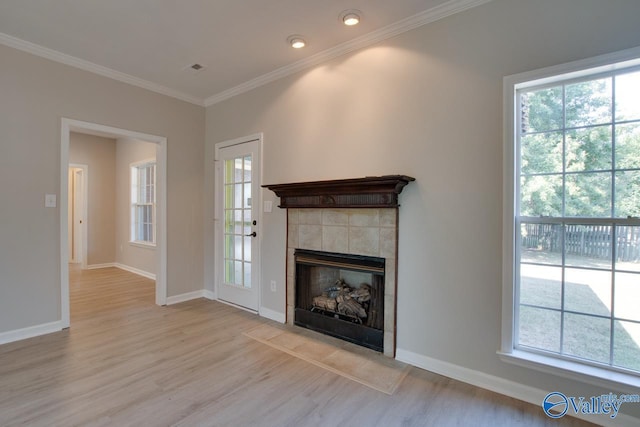 unfurnished living room with ornamental molding, a wealth of natural light, and light wood-type flooring
