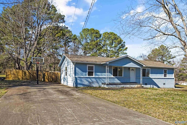 ranch-style house featuring covered porch, brick siding, fence, crawl space, and a front yard