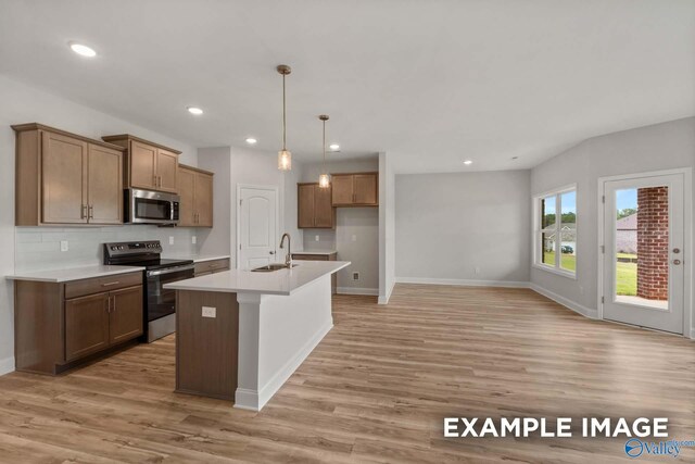 297 Keller Dr, Hazel Green, AL 35750 - kitchen featuring stainless steel appliances, a sink, light wood-style floors, decorative backsplash, and an island with sink