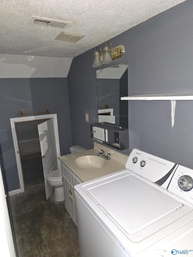 clothes washing area featuring sink, a textured ceiling, and washer / dryer