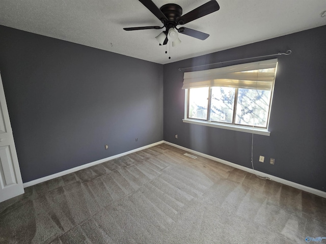 carpeted spare room featuring ceiling fan and a textured ceiling