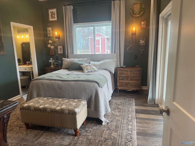 bedroom featuring dark wood-type flooring and ensuite bath