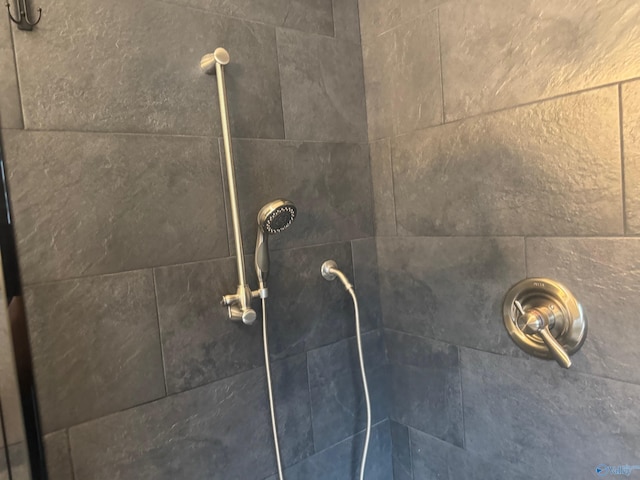 interior details featuring a tile shower