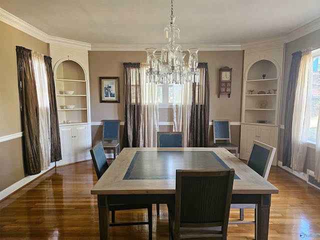 dining space with ornamental molding, built in shelves, an inviting chandelier, and wood finished floors