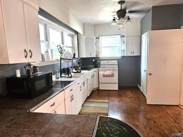 kitchen with white cabinetry, dark wood-type flooring, black microwave, and white range with electric stovetop