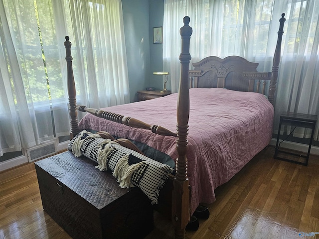 bedroom featuring wood finished floors and visible vents