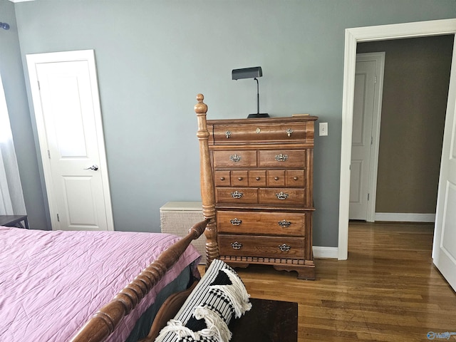 bedroom with baseboards and dark wood-style flooring