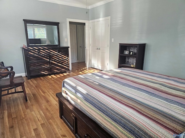 bedroom featuring wood finished floors, baseboards, and ornamental molding