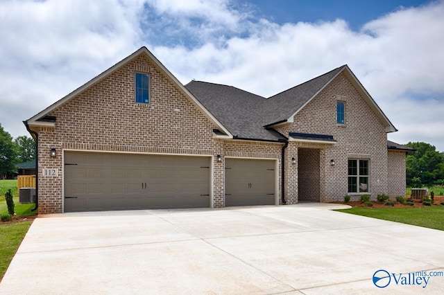 view of front of house featuring a front yard, an attached garage, a shingled roof, concrete driveway, and brick siding