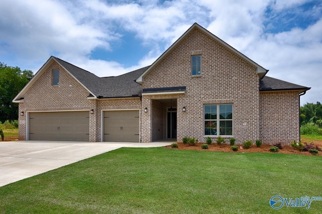 view of front of property featuring brick siding, a front yard, and a garage