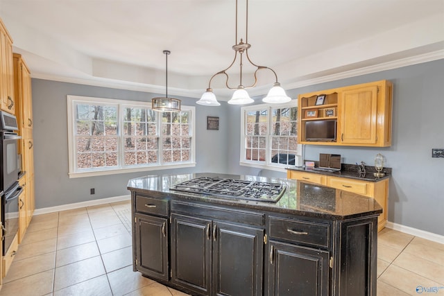 kitchen with stainless steel gas stovetop, a raised ceiling, hanging light fixtures, light tile patterned floors, and a kitchen island