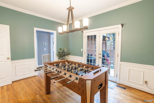 playroom featuring french doors, light hardwood / wood-style flooring, and crown molding