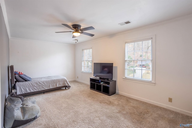 carpeted bedroom with ceiling fan, ornamental molding, and multiple windows