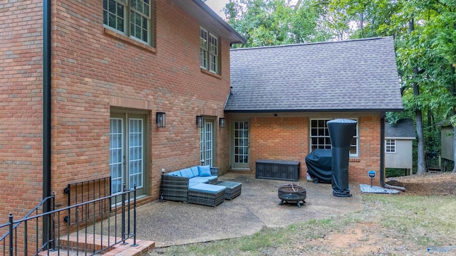 rear view of house with an outdoor living space with a fire pit and a patio area