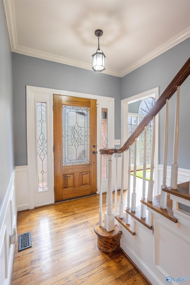 entryway featuring light hardwood / wood-style floors and ornamental molding