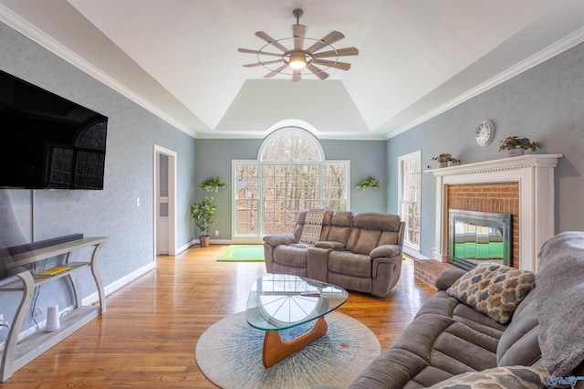 living room featuring light wood-type flooring, vaulted ceiling, ceiling fan, and crown molding