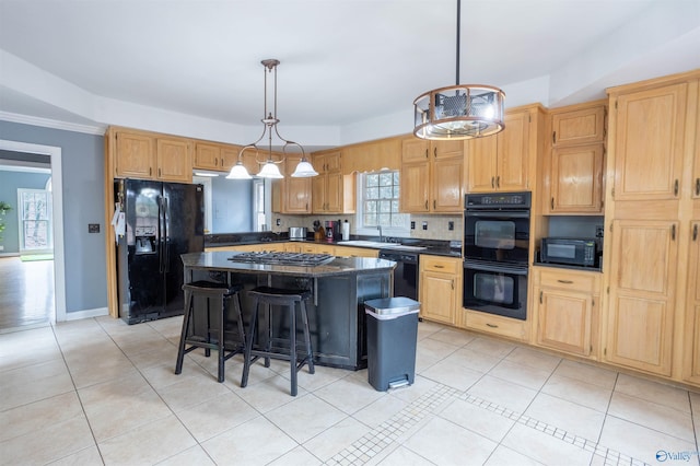 kitchen with a wealth of natural light, a kitchen island, hanging light fixtures, and black appliances