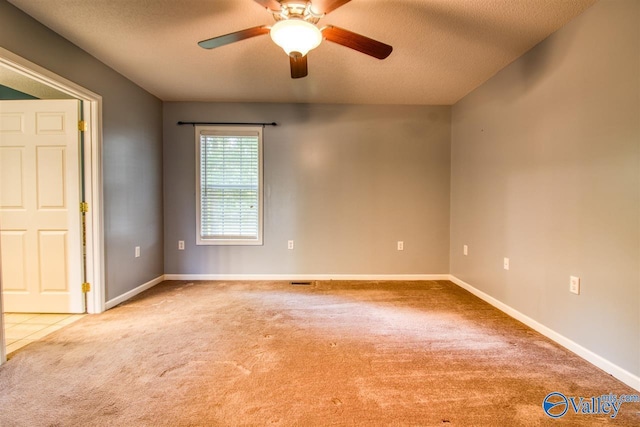 carpeted empty room featuring baseboards, a textured ceiling, and a ceiling fan
