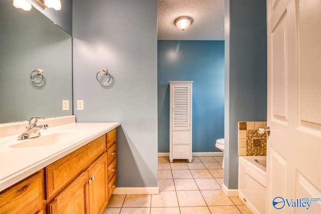 bathroom with vanity, baseboards, tile patterned flooring, a textured ceiling, and toilet