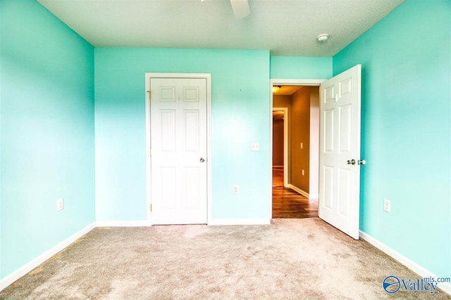 unfurnished bedroom with ceiling fan, baseboards, and carpet