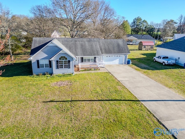 ranch-style home featuring a porch, an attached garage, concrete driveway, and a front lawn