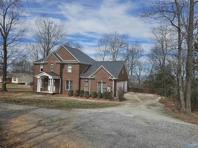 view of front facade with a garage, driveway, and brick siding