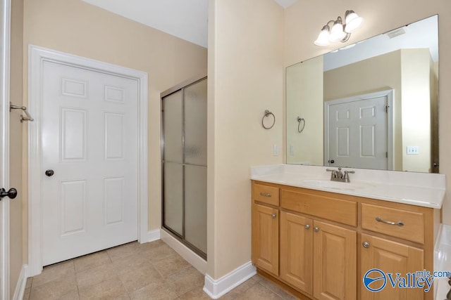 bathroom featuring tile patterned flooring, a shower with door, and vanity