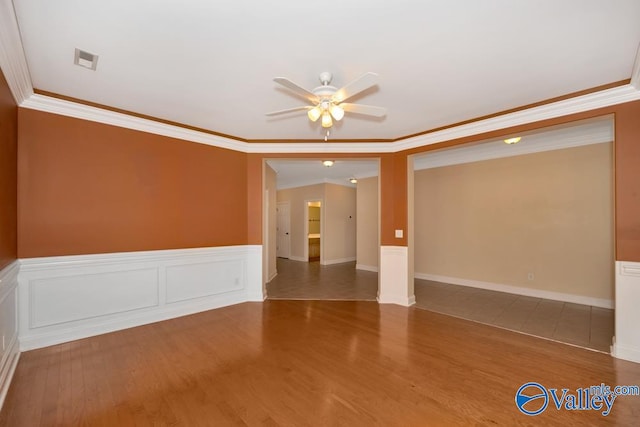 spare room featuring hardwood / wood-style flooring, crown molding, and ceiling fan