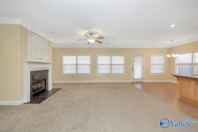 unfurnished living room featuring a wealth of natural light, carpet flooring, and a tiled fireplace