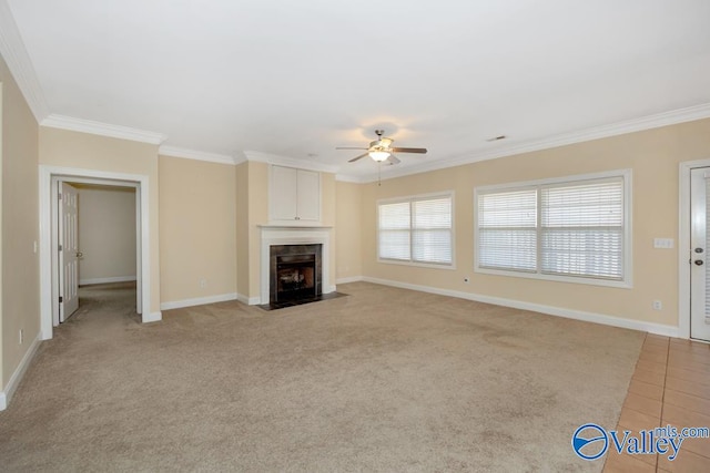 unfurnished living room with ceiling fan, ornamental molding, light colored carpet, and a fireplace